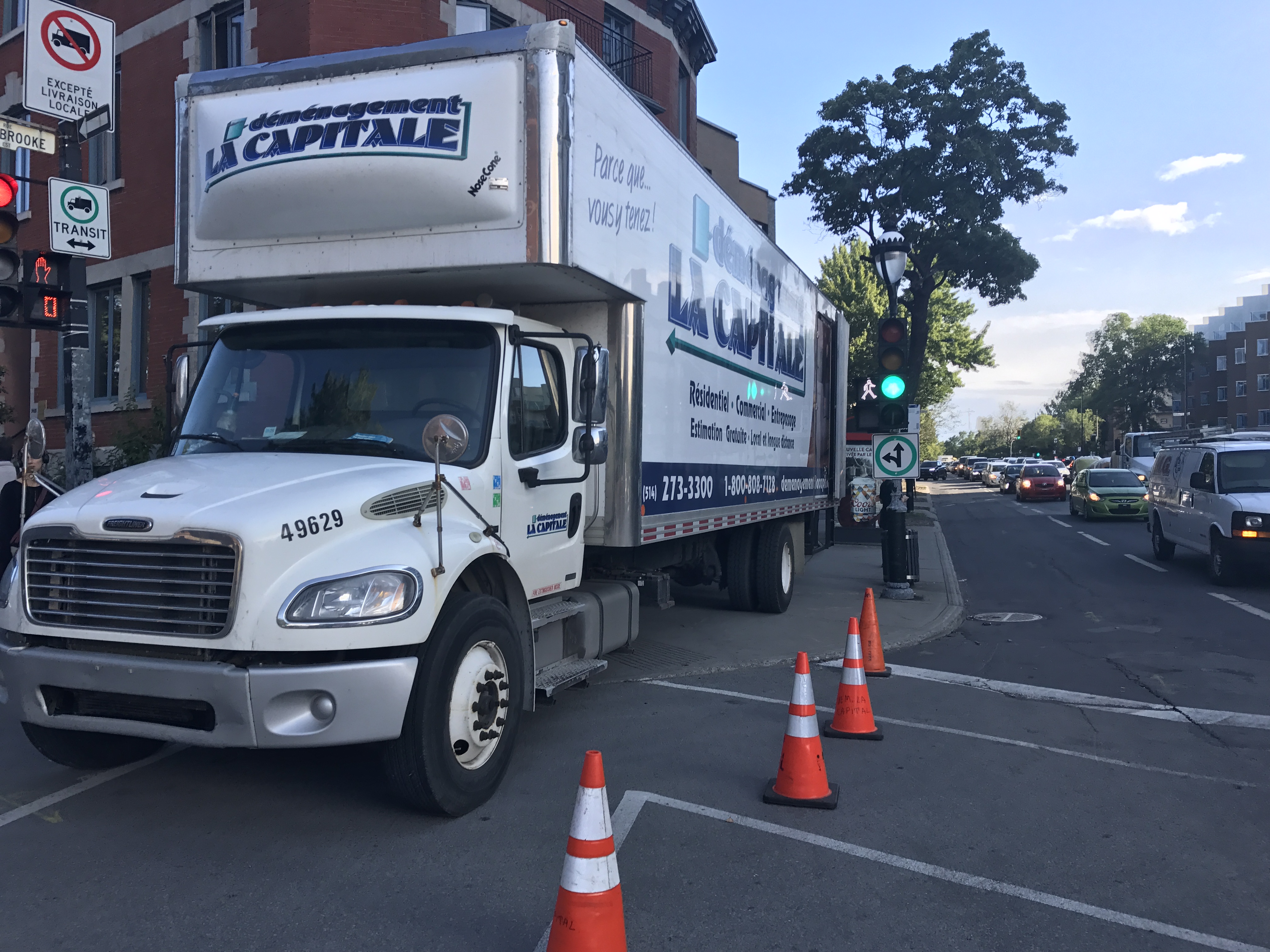 Another moving truck blocking the corner and both directions of the sidewalk