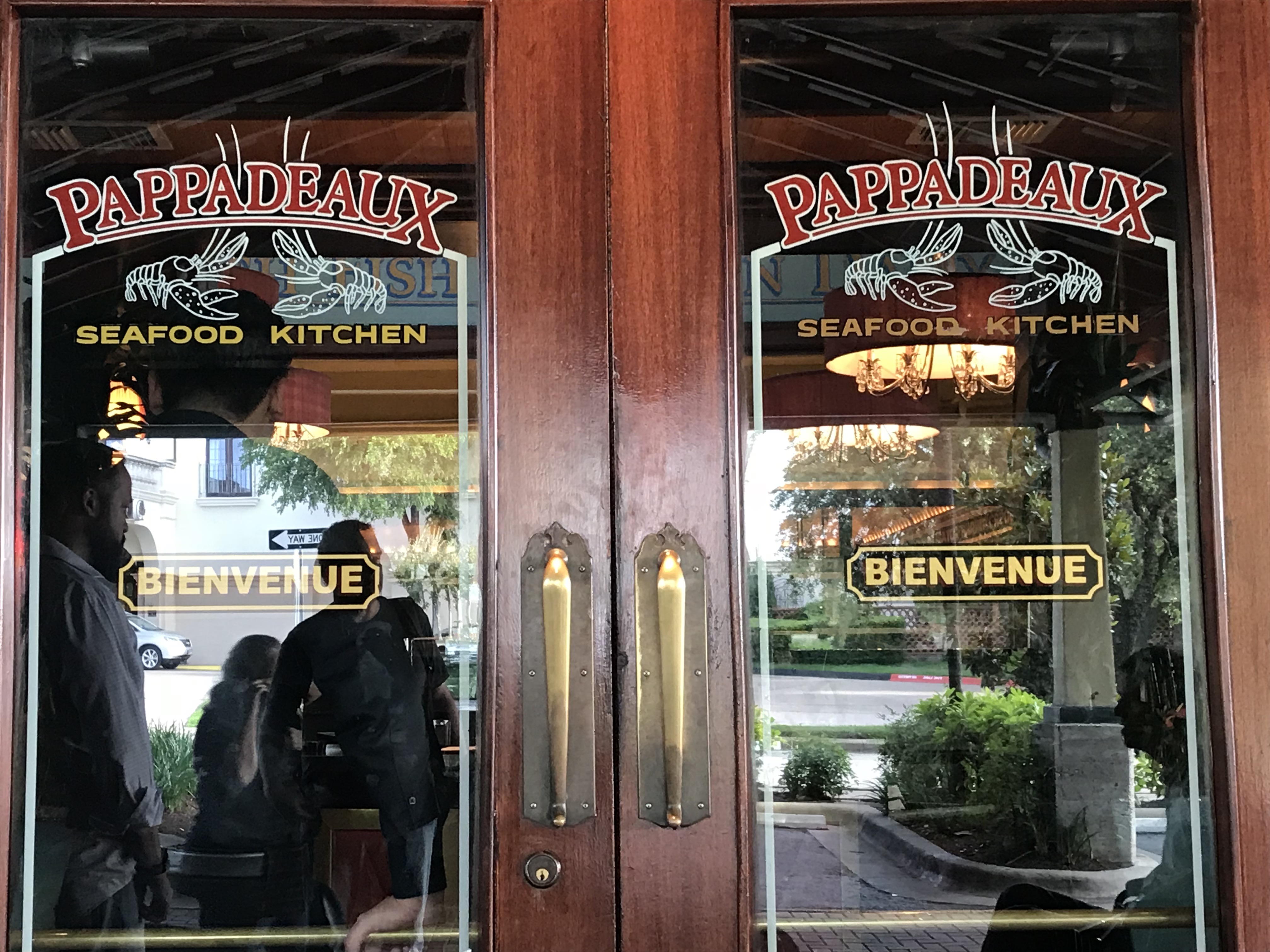 Two glass doors with the restaurant name and the word "Bienvenue", or welcome, in French