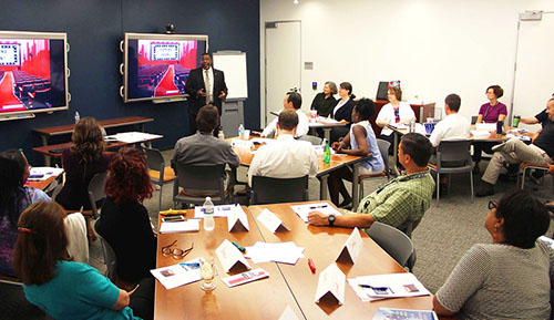 A group of diverse people in a meeting room, attending a training.